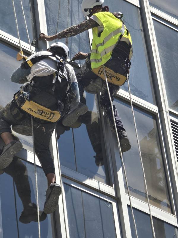 Trabalho em altura por rapel — limpeza de fachada de vidro