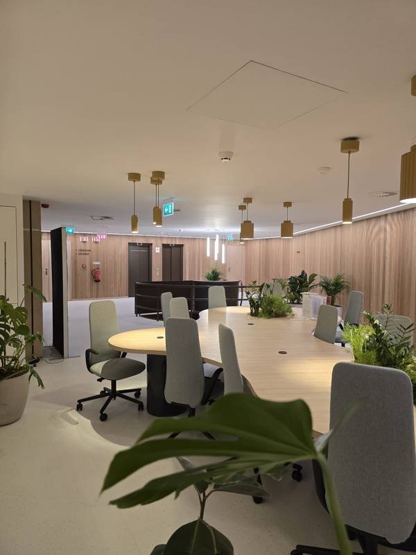 Sala de reunião corporativa com revestimento de madeira e teto acústico